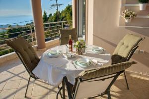 a dining table and chairs with a view of the ocean at Lila's Villa in Nerotriviá