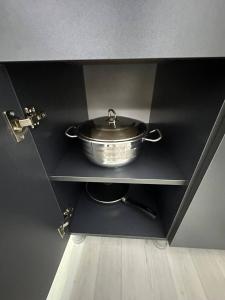 a pot on a shelf in a black cabinet at New Gudauri, Hotel Peak in Gudauri
