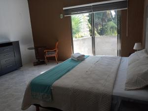 Un dormitorio con una cama grande y una ventana en El Mirador Holbox en Isla Holbox