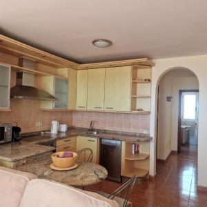 a kitchen with wooden cabinets and a counter top at Casa Sara in Costa Calma +9 photos