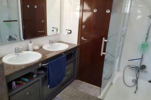a bathroom with two sinks and a shower at Casa con vistas al mar in Castelldefels +5 photos