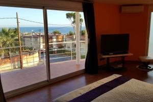 a bedroom with a large window with a view of a balcony at Casa con vistas al mar in Castelldefels