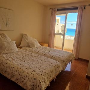 a bedroom with a bed with a view of the ocean at Casa Sara in Costa Calma