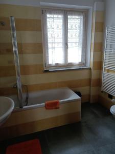 a bathroom with a bath tub and a window at Rosatea B&B in Chieri