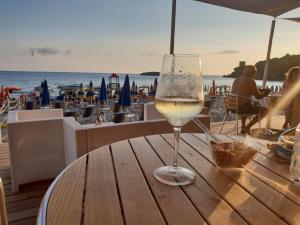 un bicchiere di vino seduto su un tavolo vicino alla spiaggia di Macinelle a Marina di Camerota