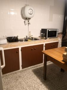 a kitchen with a sink and a microwave and a table at Finca La Pimienta in Pizarra