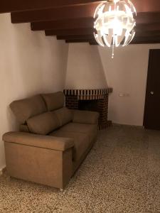 sala de estar con sofá y chimenea en Finca La Pimienta en Pizarra