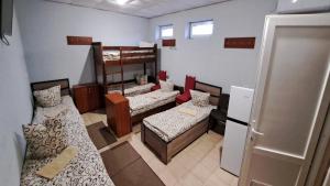 a room with three beds and a refrigerator in it at Мотель ОК in Shepetivka