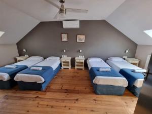 1 dormitorio con 4 camas en una habitación en LA RECREATION _ Ancienne école de 1850 rénovée en maison d'hôtes, en Missillac