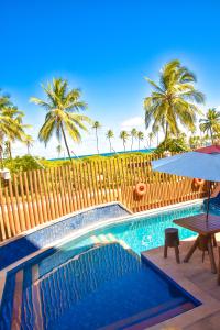 uma piscina com uma mesa e um guarda-sol em Villaggio Orizzonte em Salvador