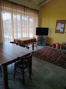 ein Wohnzimmer mit einem Tisch und einem Flachbild-TV in der Unterkunft Rosatea B&B in Chieri
