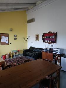 ein Wohnzimmer mit einem Sofa und einem Tisch in der Unterkunft Rosatea B&B in Chieri