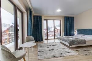 um quarto com uma cama e uma grande janela em Elena Spa Resort em Bukovel