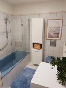 ein Badezimmer mit einer blauen Badewanne und einer Dusche in der Unterkunft Haus Rosenbusch in Sinzing