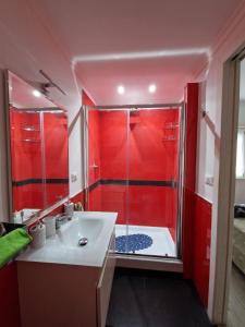 ein rotes Badezimmer mit einer Dusche und einem Waschbecken in der Unterkunft Casa Altomare in Ladispoli