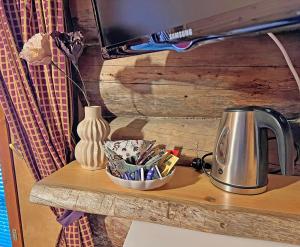 a table with a tea kettle and a vase on it at Hotelli Vuorikelo in Muurame