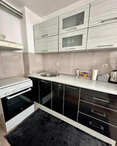 a small kitchen with a sink and a stove at Stan na dan - Apartman Bella in Lukavica +4 photos