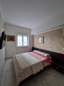 ein Schlafzimmer mit einem Bett und einer Ziegelwand in der Unterkunft Casa Altomare in Ladispoli