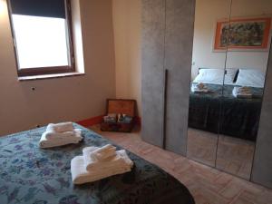 ブーチネにあるAppartamento Biricocoloのベッドルーム1室(ベッド1台、鏡、タオル付)