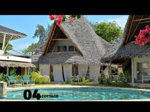 uma casa com telhado de palha e uma piscina em 04 beach cottage malindi em Malindi