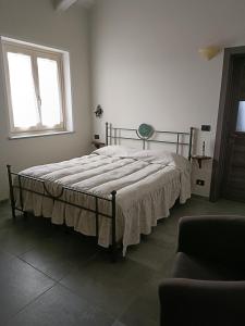 Bett in einem weißen Zimmer mit Fenster in der Unterkunft Rosatea B&B in Chieri