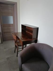 ein Klavier neben einem Stuhl und einer Couch in der Unterkunft Rosatea B&B in Chieri