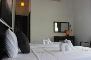 a bedroom with two beds with towel animals on them at Hoi An Viet House Homestay in Hoi An