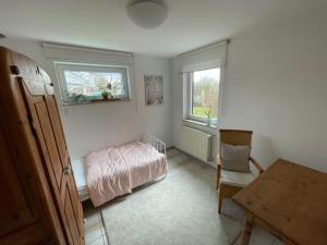 Schlafzimmer mit einem Bett, einem Tisch und einem Fenster in der Unterkunft Haus Rosenbusch in Sinzing