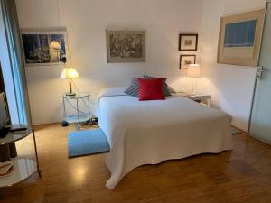 a bedroom with a large white bed with a red pillow at CASABELLA-LAGO MAGGIORE in Lesa +171 photos