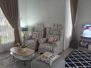 a living room with a couch and a chair at Adinda Syariah C-10 Bukit Gardenia Resort in Tarogong