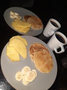 two plates of breakfast food with pancakes and fruit at Ocean view in Monteverde Costa Rica