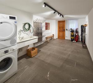 een wasruimte met een wasmachine en een wastafel bij AHORN7 in Reit im Winkl