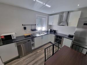 a kitchen with stainless steel appliances and a wooden table at Natura House in Aveiro