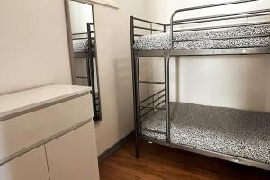 a room with three bunk beds and a mirror at Helena House in Senhora da Hora
