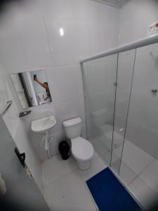 een witte badkamer met een toilet en een douche bij Suítes good trip Itacare sem estacionamento in Itacaré