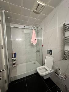 biała łazienka z toaletą i prysznicem w obiekcie Kozapark Rezidans 1+1 w mieście Esenyurt