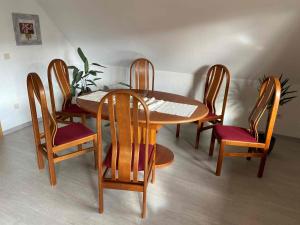 een houten tafel en stoelen in een kamer bij Kleine Elbequelle in Wolfhagen