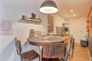 een keuken met een tafel en stoelen in een kamer bij Le carpe diem, appt à 10 min de Nîmes in Bouillargues