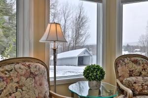 um quarto com duas cadeiras, uma mesa e uma janela em The Birch Ridge- European Room #8 - King Suite in Killington, Vermont, Hot Tub, home em Killington