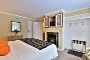 una camera con letto e camino di The Birch Ridge- European Room #8 - King Suite in Killington, Vermont, Hot Tub, home a Killington
