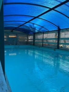 een groot zwembad met een blauw plafond bij skyZimmer network-Ahuzat omanim in Ani'am