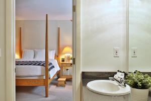uma casa de banho com uma cama e um lavatório num quarto em The Birch Ridge- Blue Velvet Room #10 - Queen Suite in Killington, Vermont, Hot Tub, Lounge, home em Killington