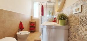 un bagno con un water e un lavandino di Casa SantaBarbara a Marina di Ragusa Altre 42 foto