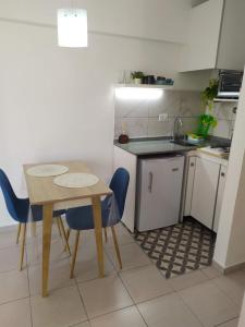 uma pequena cozinha com uma mesa e cadeiras azuis em Cañada Suites em Córdova