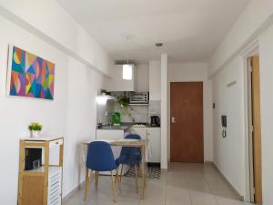 cocina y comedor con mesa y sillas en Cañada Suites en Córdoba