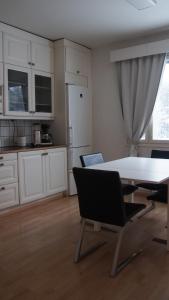ロヴァニエミにあるMetsä roomの部屋にテーブルと椅子のあるキッチン