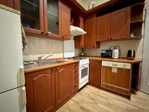 una cucina con armadi in legno e un piano cottura bianco con forno di ROMANTIC Apartments - оn Valova street a Lviv