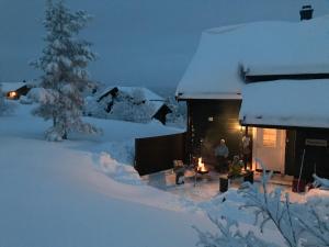 a couple of people sitting outside of a cabin in the snow at Vrådal Panorama - Flott hytte på toppen in Sinnes