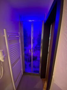 リート・イム・オーバーインタールにあるGasthof Rieder Stubnの紫色の照明のある部屋への扉付きの廊下