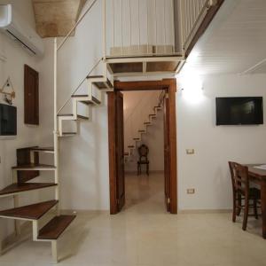 uma escada em caracol num quarto com uma mesa e cadeiras em Lo Scrigno Barocco em Lecce